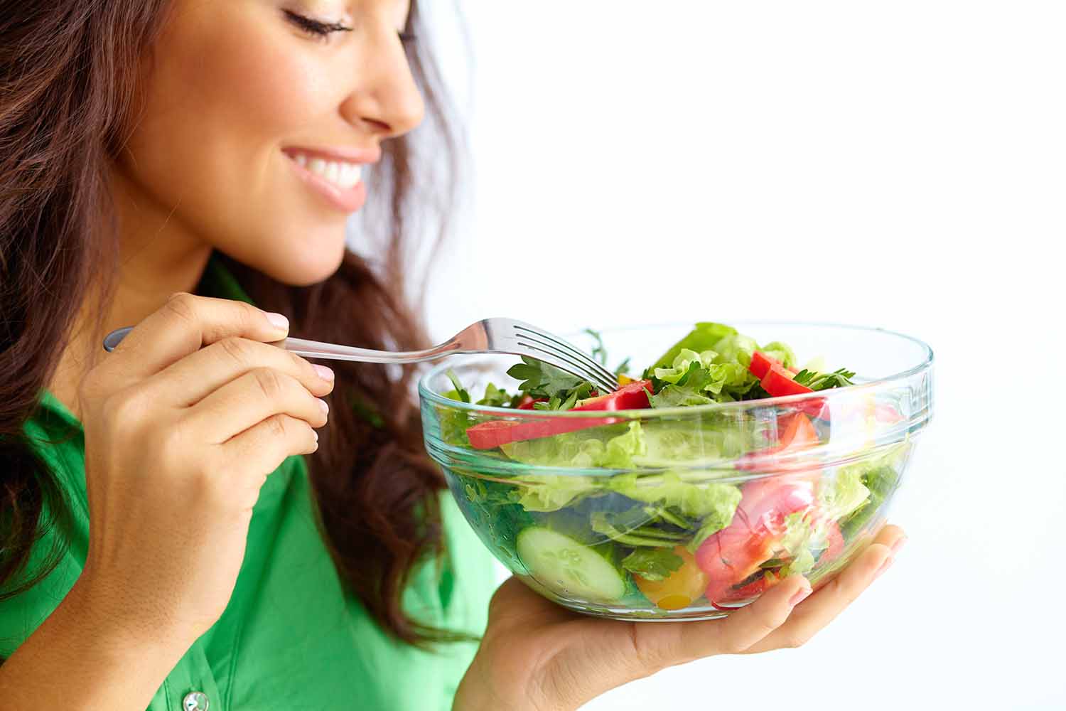 Sentimento de saciedade e prazer ao comer: mulher comendo uma salada saudável, ilustrando a conexão entre uma boa alimentação e o controle da fome pelo hipotálamo.